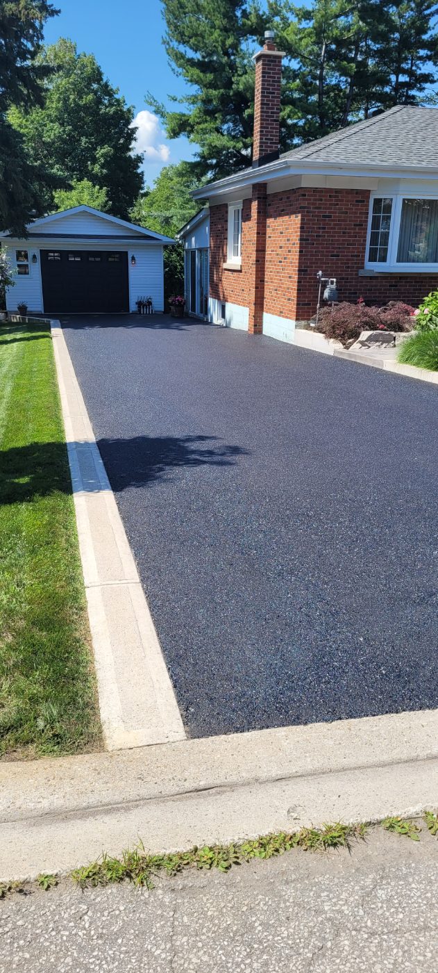 Sealed driveway running to a detached garage, sharp masked borders