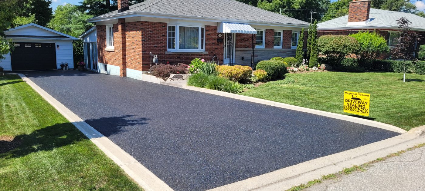 Freshly sealed asphalt driveway with clean concrete edging, Waterdown ON